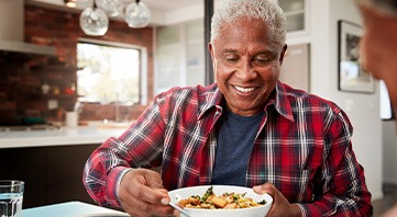 Senior man filling plate at table
