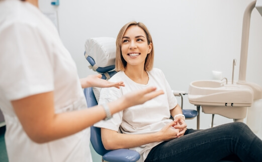 Woman in dental chair smiling at dentist