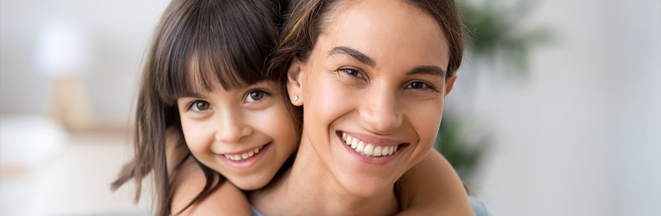 Mother and child with healthy smile after restorative dentistry