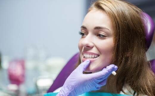 Dentist examining patient's smile after dental crown restoration