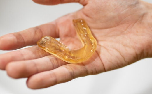 Person holding a nightguard for bruxism