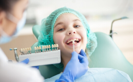 Child's smile compared to tooth colored filling shades