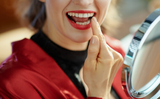 Woman pointing to smile after cosmetic dental bonding