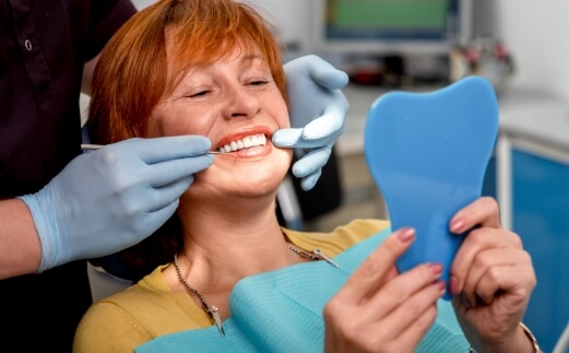 Woman smiling and enjoying the benefits of dental implants
