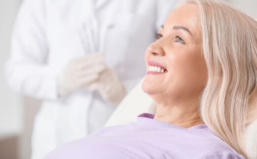 Woman smiling after dental implant tooth replacement