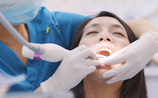 Dental patient receiving scaling and root planing
