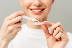 Woman using professional grade teeth whitening kit